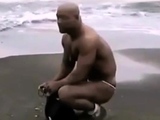 Asian bodybuilder barely covered at the beach