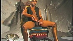 Sexy black stud sits on a chair and feeds his desire for masturbation